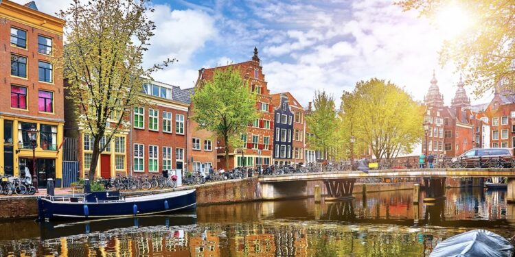 Channel in Amsterdam Netherlands houses river Amstel landmark old european city spring landscape.